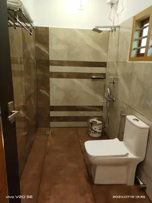 a bathroom with a toilet and a shower at Merlys Fruit Garden in Cochin