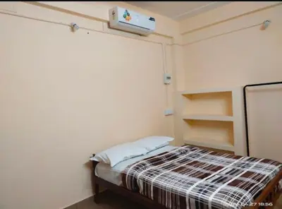 a small bedroom with a bed with a heater on the wall at Merlys Fruit Garden in Cochin