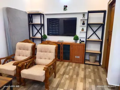 a living room with two chairs and a television at Merlys Fruit Garden in Cochin