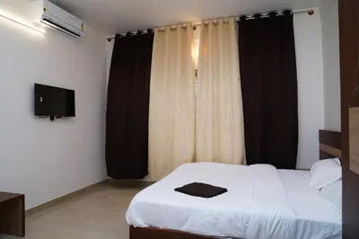 a bedroom with a bed with a black and white curtain at Meridian Rooms and Service Apartment in Mysore