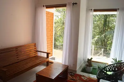 a wooden bench in a room with a window at Vihaara Wayanad Serviced Villa in Ambalavayal