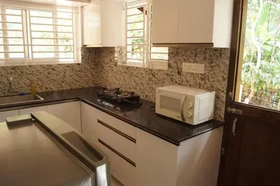 a kitchen with a microwave on a black counter at Vihaara Wayanad Serviced Villa in Ambalavayal