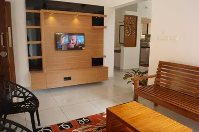 a living room with a tv on a wooden wall at Vihaara Wayanad Serviced Villa in Ambalavayal