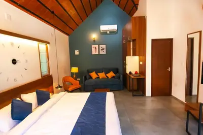 a bedroom with a large bed and a couch at Bay View Suites, Vythiri, Wayanad in Wayanad