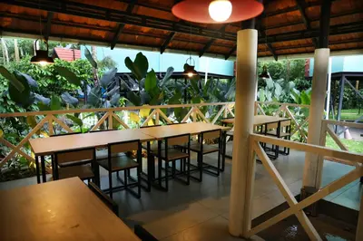 a restaurant with wooden tables and chairs and plants at Bay View Suites, Vythiri, Wayanad in Wayanad