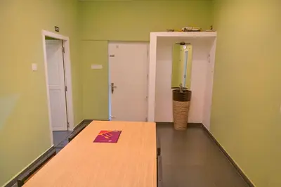 a room with a wooden table in a room with green walls at Bay View Suites, Vythiri, Wayanad in Wayanad