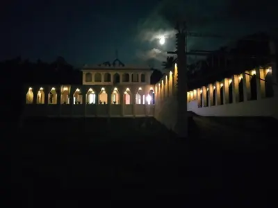 a building at night with a moon in the sky at JK Home stay in Sultan Bathery