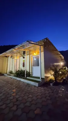 a small house with a garage at night at Ibex Resorts, Valparai Mistly in Vālpārai