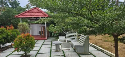 a bench and chairs in a garden with a gazebo at CASA DE CANOLI - A Private backwater villa in Kodungallūr