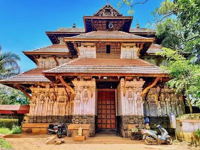a building with two motorcycles parked in front of it at CASA DE CANOLI - A Private backwater villa in Kodungallūr