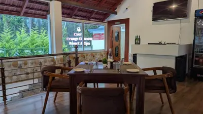 a dining room with a wooden table and chairs at Coorg Orange Blossom Resort and Spa in Suntikoppa