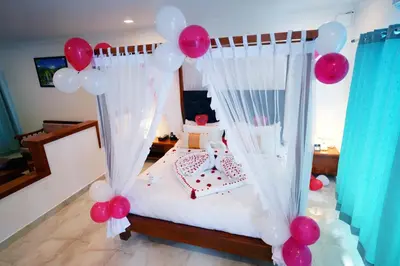 a bedroom with a canopy bed with pink and white balloons at Coorg Orange Blossom Resort and Spa in Suntikoppa