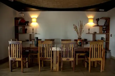 a dining room with a wooden table and chairs at O'Land Wilderness Lodge in Kolakambe