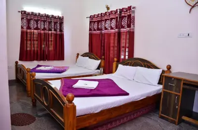 two beds in a room with red curtains at Misty Meadows in Kodaikānāl
