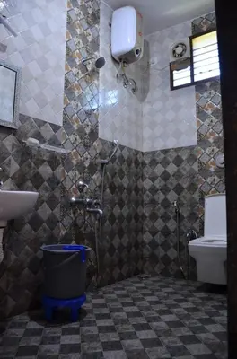 a bathroom with a shower and a sink and a toilet at Misty Meadows in Kodaikānāl