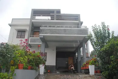 a white building with a lot of plants at Misty Meadows in Kodaikānāl