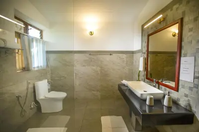 a bathroom with a sink and a toilet at Sinna Dorai's Rotti Kadai Bungalow in Vālpārai