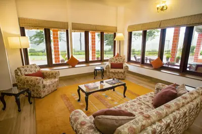 a living room with couches and chairs and windows at Sinna Dorai's Rotti Kadai Bungalow in Vālpārai