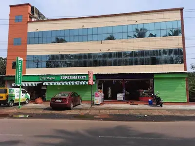 a green building with a car parked in front of it at Kandengath Residency and Lodge in Mulagunnathukāvu