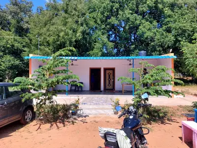 a house with a motorcycle parked in front of it at GO2 Village Homestay in Pennāgaram
