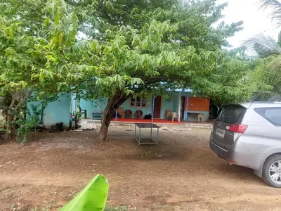 a car parked in front of a house with a tree at GO2 Village Homestay in Pennāgaram