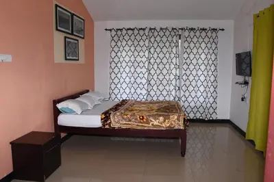 a bed in a room with a window and a bed sidx sidx sidx at Elk Hill Palace in Ooty