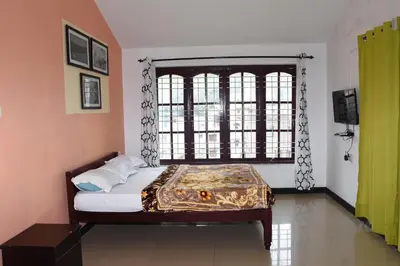 a bedroom with a bed and a large window at Elk Hill Palace in Ooty