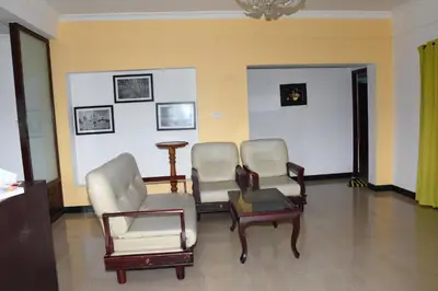 a waiting room with three chairs and a table at Elk Hill Palace in Ooty