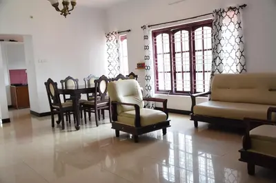 a living room with chairs and a dining room table at Elk Hill Palace in Ooty