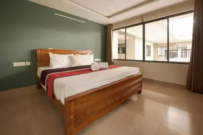 a bedroom with a bed and a large window at Span Avenue in Kozhikode