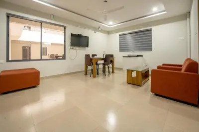 a living room with a couch and chairs and a table at Span Avenue in Kozhikode