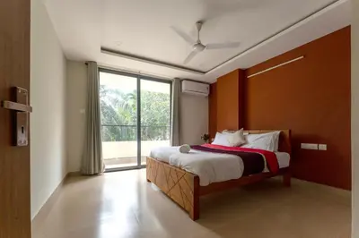 a bedroom with a bed and a large window at Span Avenue in Kozhikode