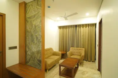 a living room with two chairs and a table at Hotel Devalokam in Trittāla