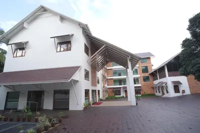 a white building with a black roof at Hotel Devalokam in Trittāla