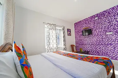 a bedroom with a purple accent wall and a bed at Via Bala Garden in Ooty