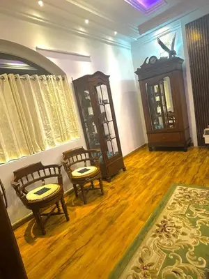 a living room with two chairs and a wooden floor at The Misty Valley in Kodanād