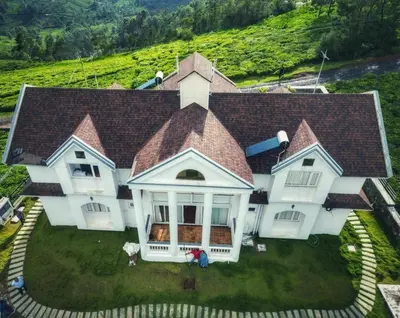 an aerial view of a large white house at The Misty Valley in Kodanād
