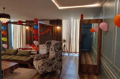 a living room with a couch and a chair and balloons at Vilasini Inn in Maddūr