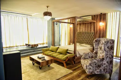 a bedroom with a bed and a couch and a chair at Vilasini Inn in Maddūr