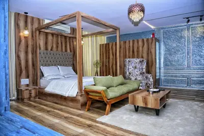 a bedroom with a canopy bed and a chair at Vilasini Inn in Maddūr