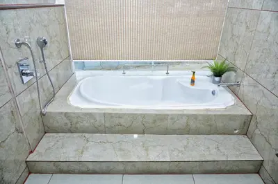 a bath tub in a bathroom with a shower at Vilasini Inn in Maddūr