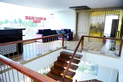 a staircase in a living room with a piano at Vilasini Inn in Maddūr
