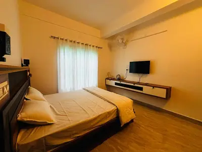 a bedroom with a large bed and a television at casa wayn homestay in Sultan Bathery
