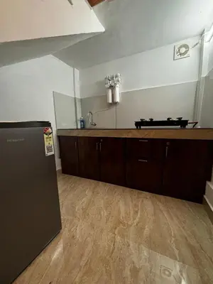a kitchen with a counter top and a refrigerator at casa wayn homestay in Sultan Bathery