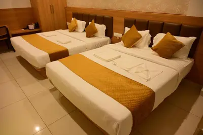 two beds sitting next to each other in a room at Bimba Hotels in Mysore