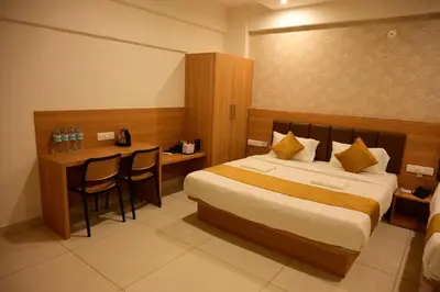 a hotel room with a bed and a table and chairs at Bimba Hotels in Mysore