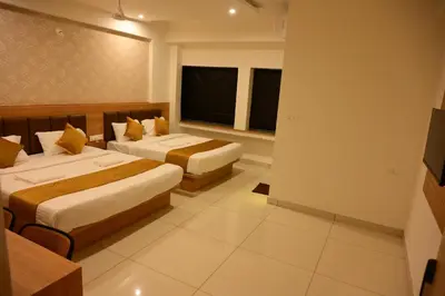 a hotel room with two beds and a window at Bimba Hotels in Mysore