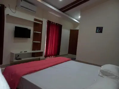 a bedroom with a large bed with a red curtain at Whiteflower Mountain Resort in Perintalmanna