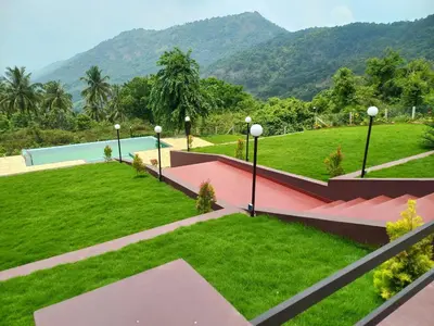 a view of a park with mountains in the background at Whiteflower Mountain Resort in Perintalmanna