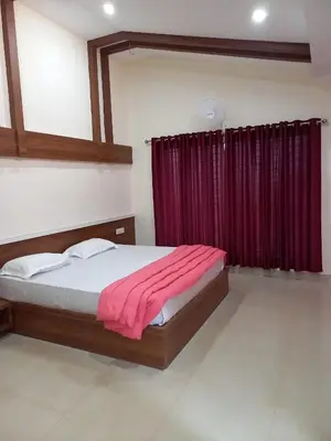 a bedroom with a bed with a red curtain at Whiteflower Mountain Resort in Perintalmanna